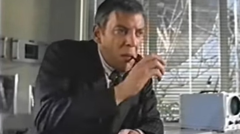 Donald Sutherland smoking in an office