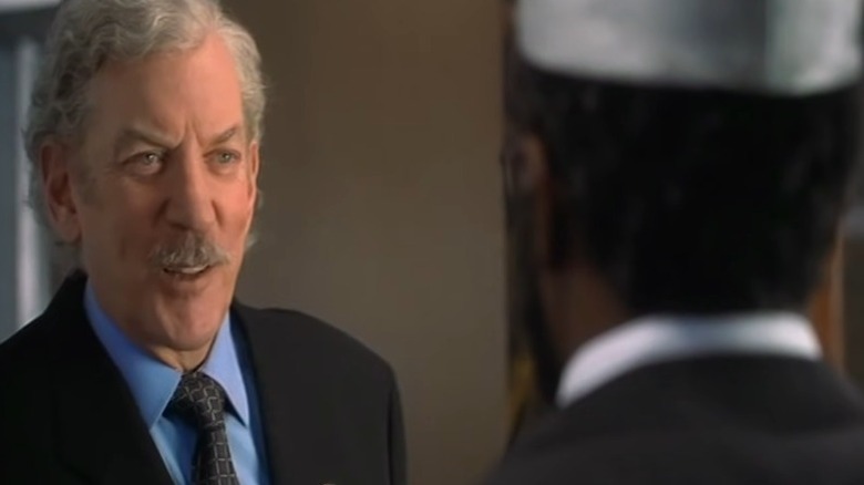 Donald Sutherland talking wearing suit