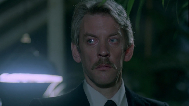 Donald Sutherland standing in greenhouse