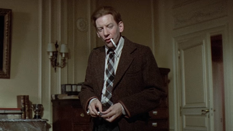 Donald Sutherland in brown suit smoking