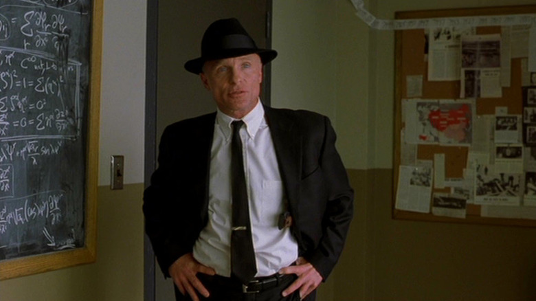 Ed Harris stands by a chalkboard