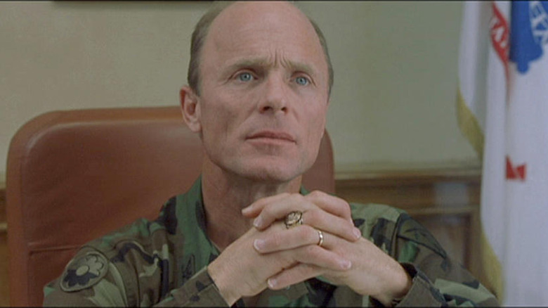 Ed Harris sits at a desk