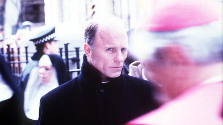 Ed Harris stands on the street