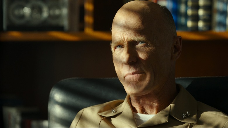 Ed Harris sits in the shadows