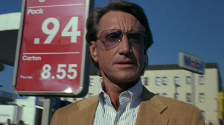 Roy Scheider in front of a gas station