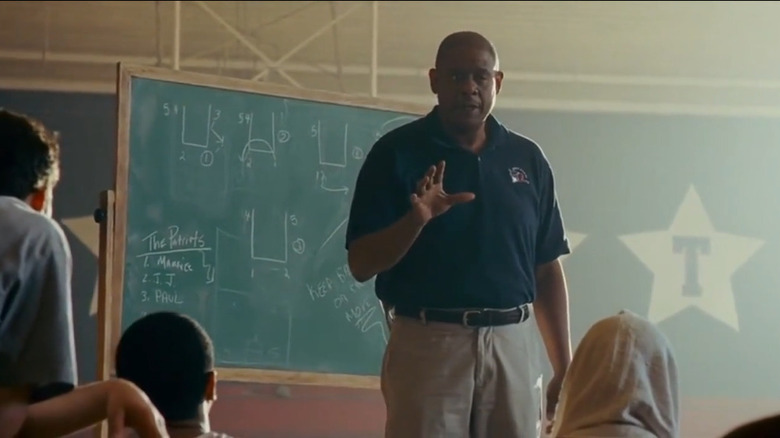 Coach Collins speaking to the team in front of blackboard