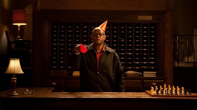 Whitaker as desk clerk where red party hat