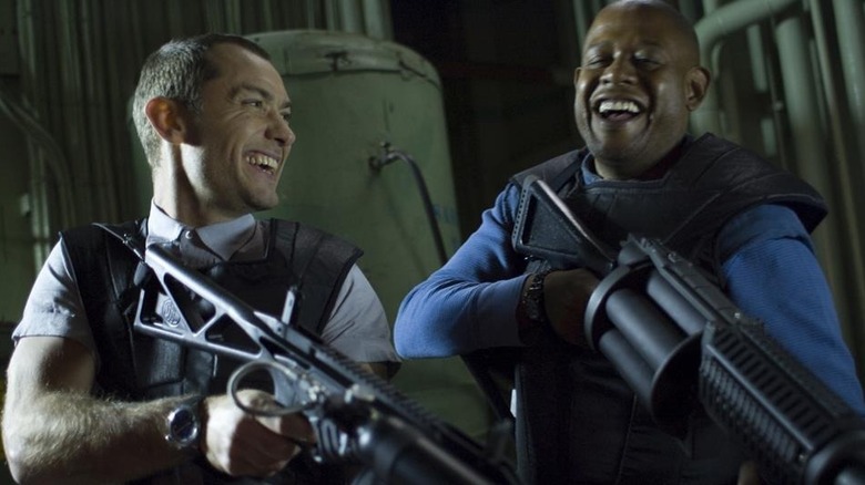 Remy and Jake laughing while holding guns