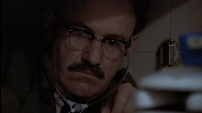 Gene Hackman crouched and listening intently