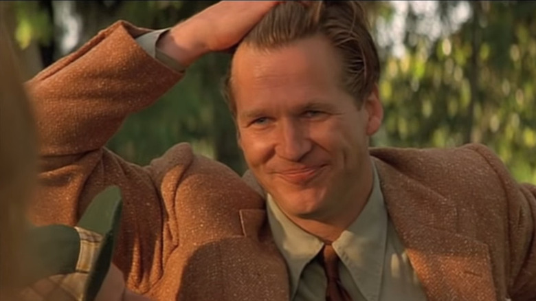 Jeff Bridges smiling and touching his hair