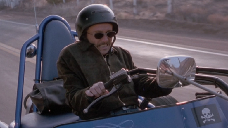 Gary Oldman drives a motorcycle