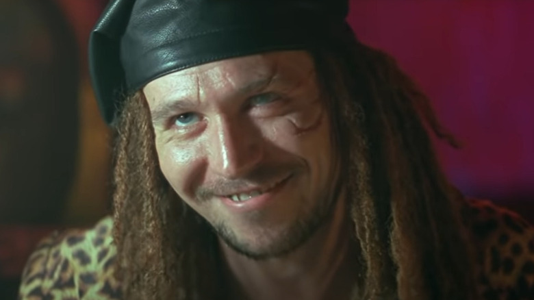 Gary Oldman with dreadlocks and a scarred face