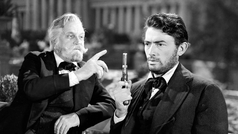 Gregory Peck holds a pistol