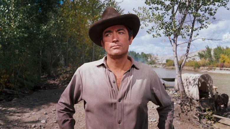 Gregory Peck stands along a river bed