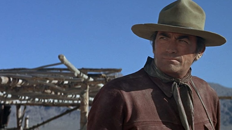 Gregory Peck stands in front of mountains