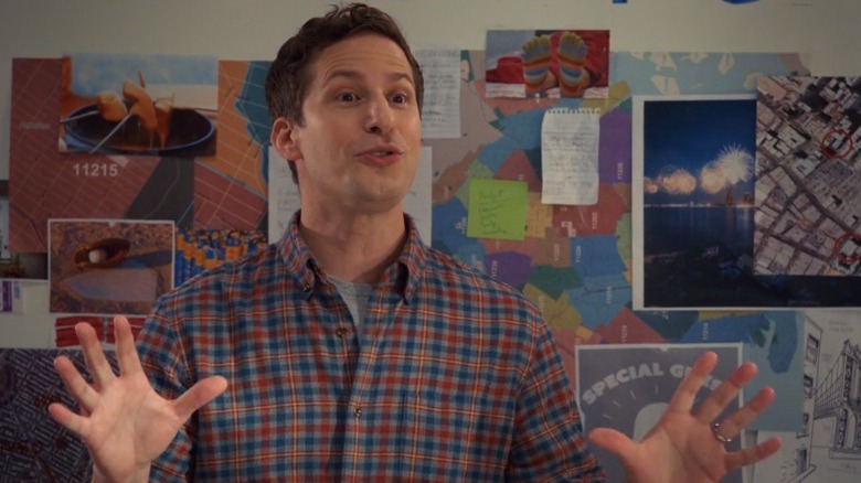 Jake Peralta gestures in front of a bulletin board