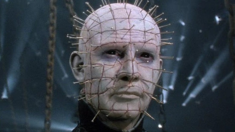 Pinhead stands amid chains