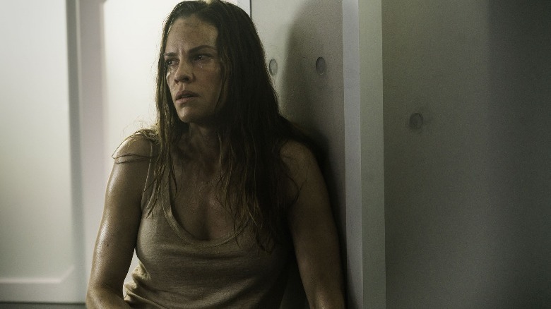 Hilary Swank sitting on floor looking scared