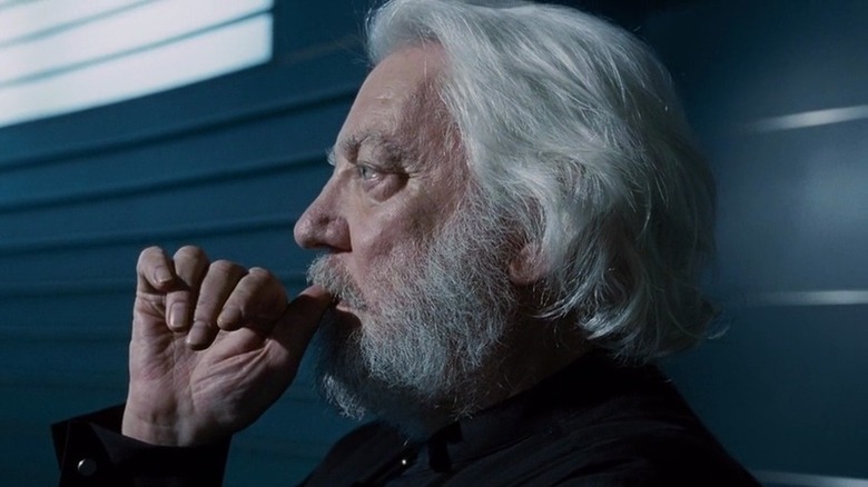 President Snow touching thumb to lip