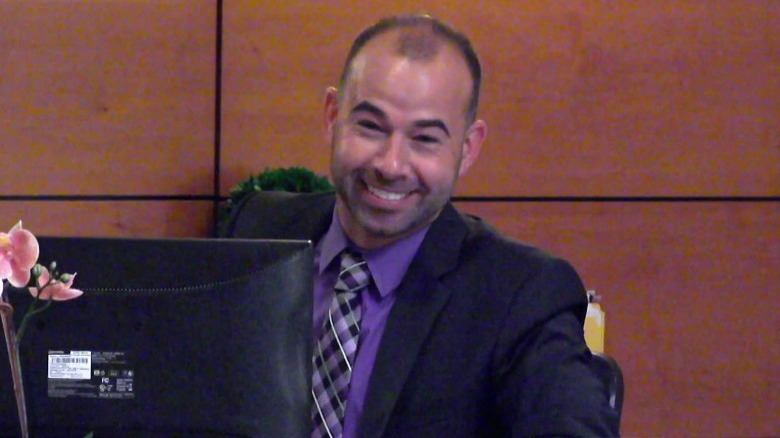 Murr behind desk smirking