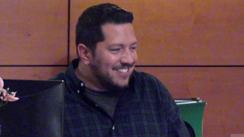 Sal behind desk laughing