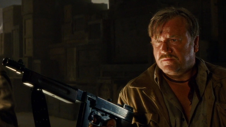 Mac betrays Indiana Jones, holding gun