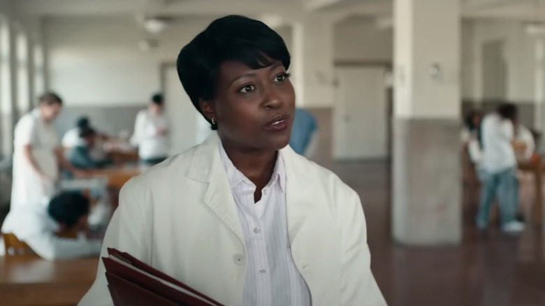 Psych Doctor holds a file folder and looks off-screen