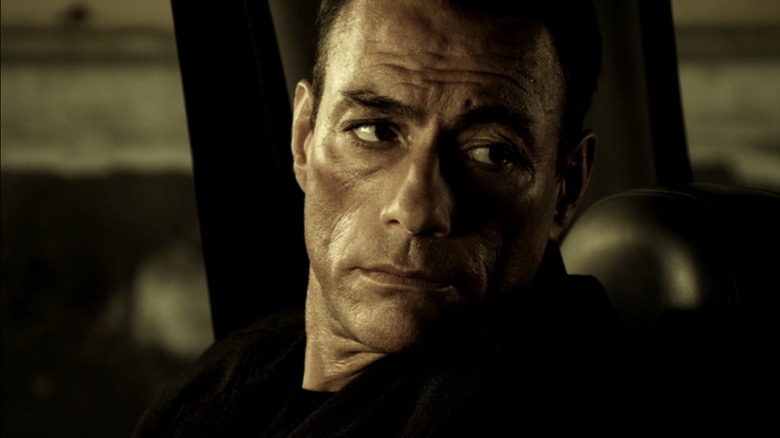 Van Damme in a car looking stern