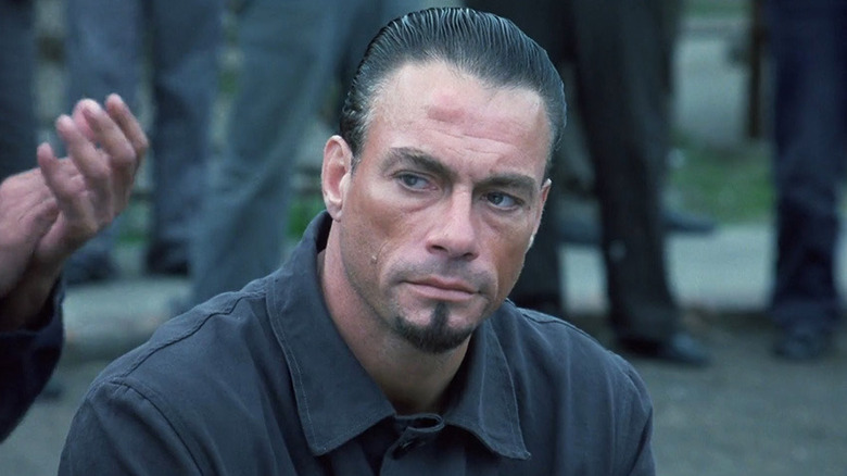 Van Damme in a prison yard with a goatee