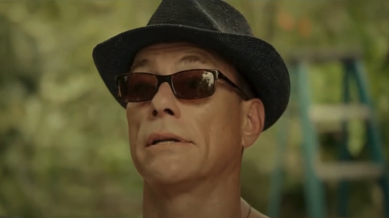 Jean-Claude Van Damme in sunglasses and a fedora