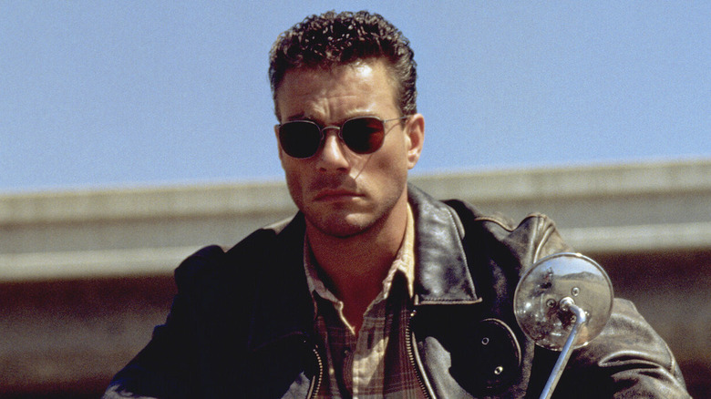 Van Damme in sunglasses and leather jacket