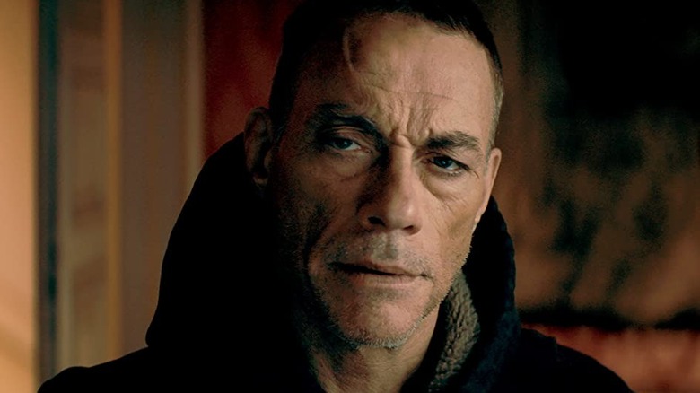 Van Damme squints in a coat