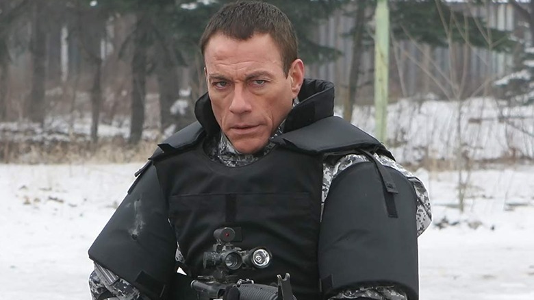 Van Damme in the forest with a gun