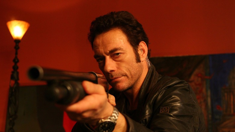 Van Damme aims a shotgun