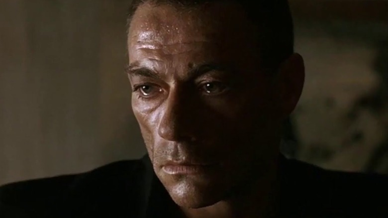 Van Damme stares left, sweaty