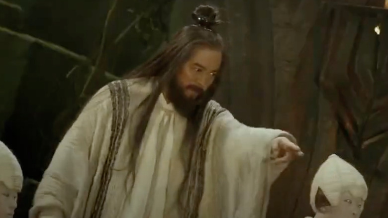 Jet Li with beard and robe pointing