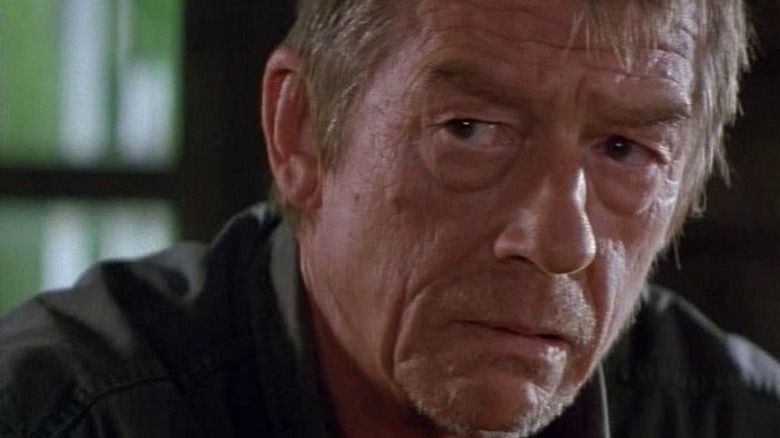 John Hurt looks left