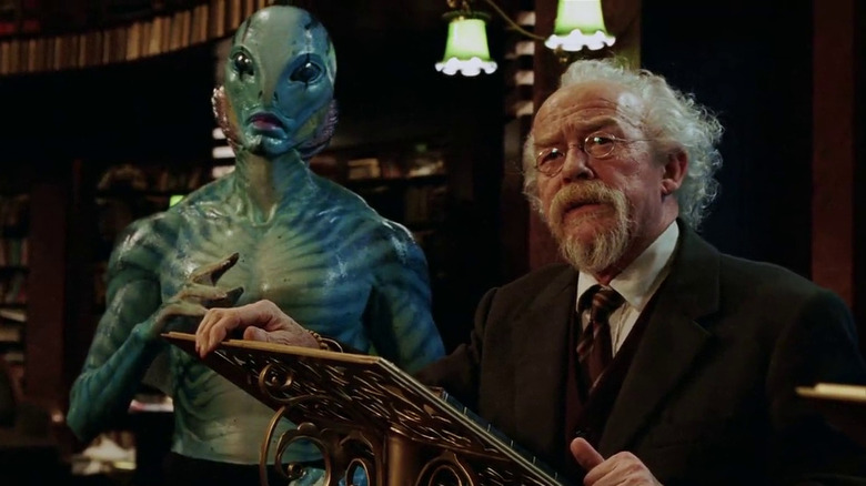 Professor Bruttenholm stands next to Abe Sapien