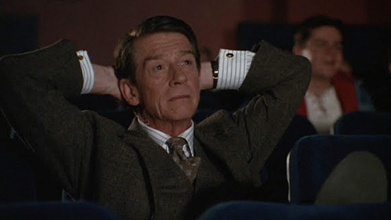Giles watches a movie in a theater