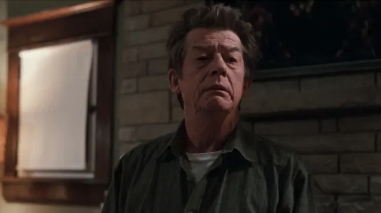 John Hurt in front of a brick wall