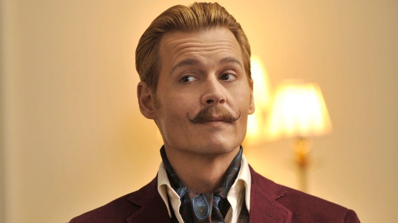 Mortdecai stands in burgundy jacket in "Mortdecai"