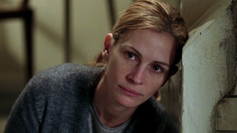 Anna leans on a wall looking upset in "Closer" (2004)