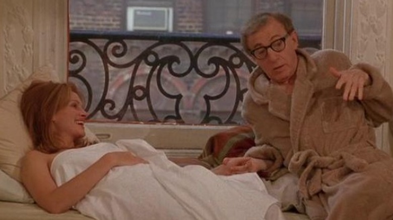 Woody Allen in a bathrobe laying with Julia Roberts