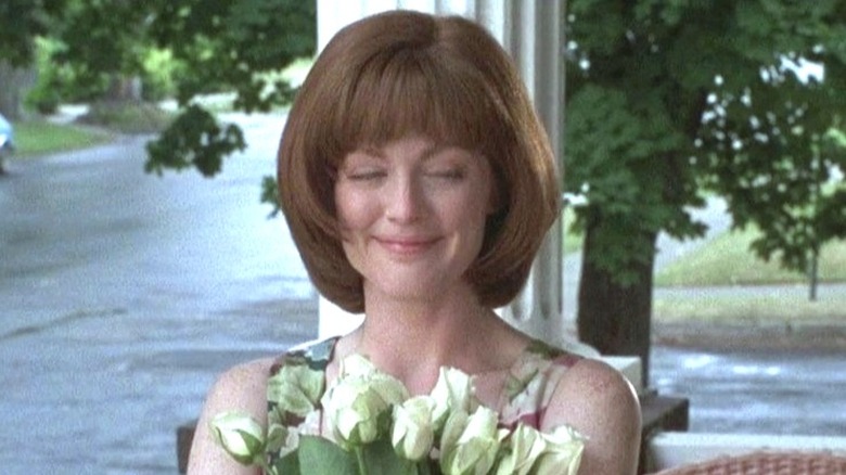 Julianne Moore holding flowers and grinning