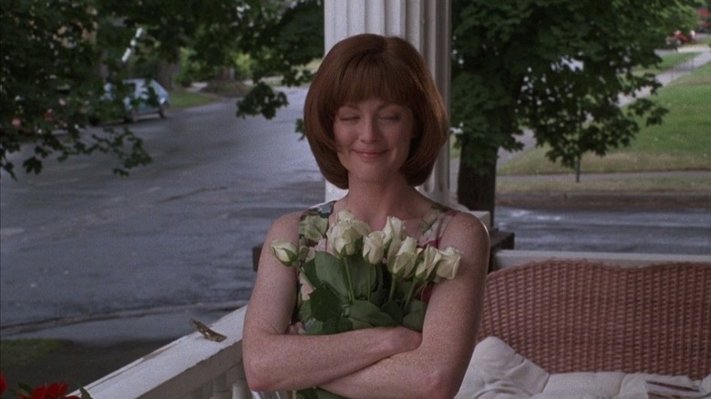 Julianne Moore holding flowers and grinning