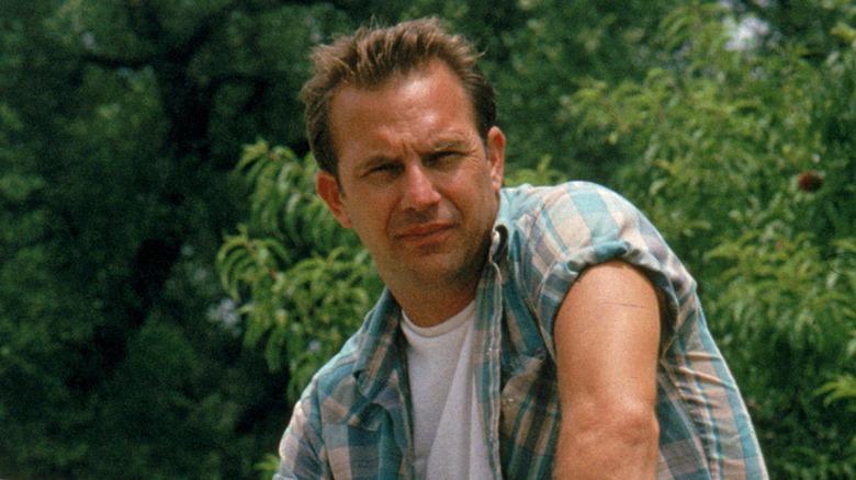 Kevin Costner sitting outdoors