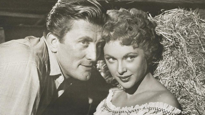 kirk douglas leans in to a woman's ear