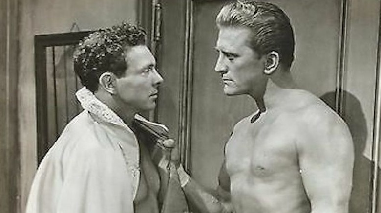 kirk douglas confronts a man in a cape