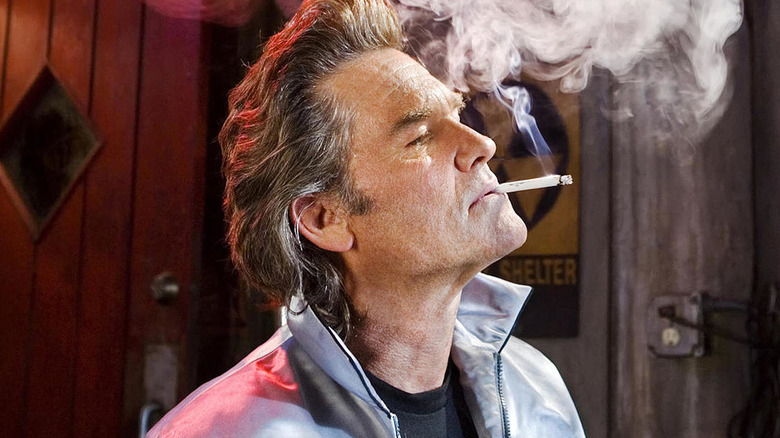 Kurt Russell smokes a cigarette