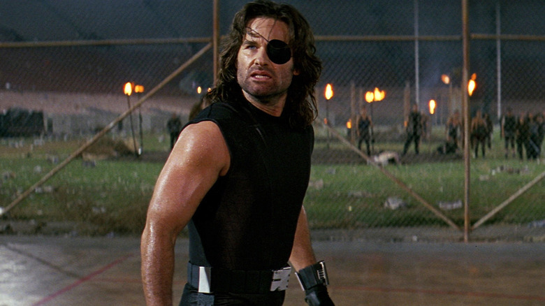 Snake Plissken in front of a fence
